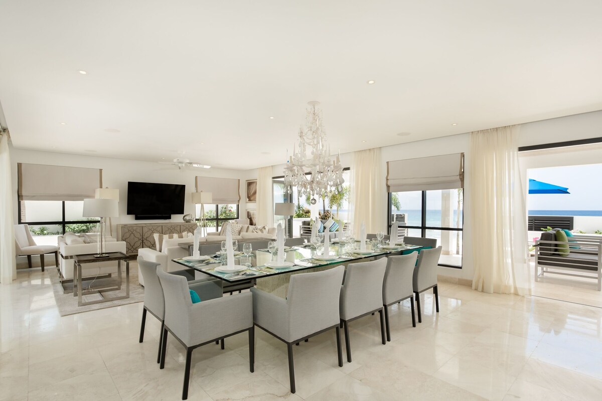 An elegant dining room adorned with fine china, polished silverware, a grand dining table, and a dazzling crystal chandelier, setting the stage for formal gatherings.