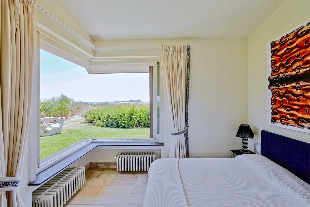 Tranquil bedroom in a luxury villa with stunning outdoor scenery.