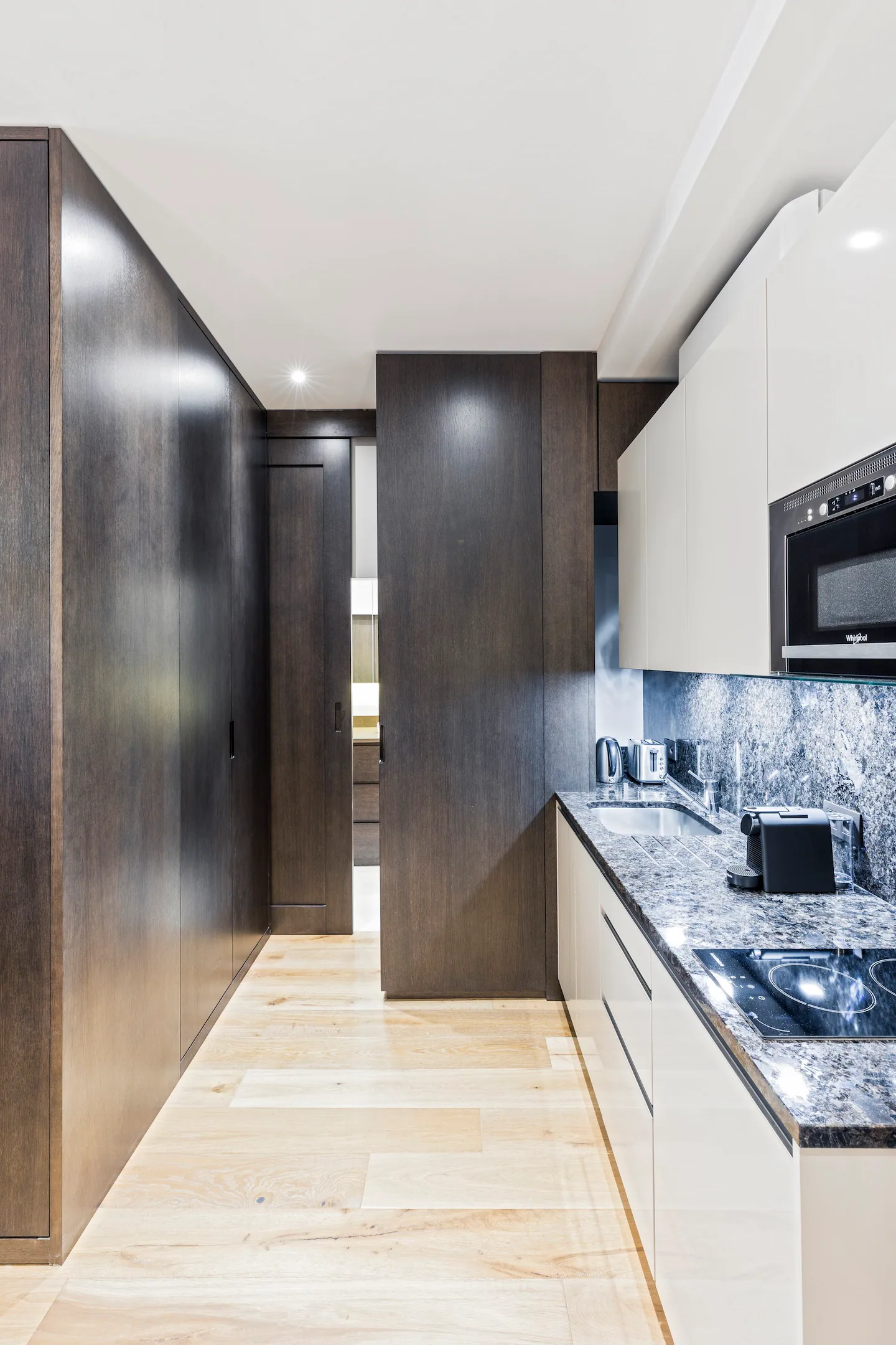 The kitchen has a fridge, stove, microwave, washer, Nespresso coffee maker, kettle, toaster, and all the utensils you need, with built-in shelves.